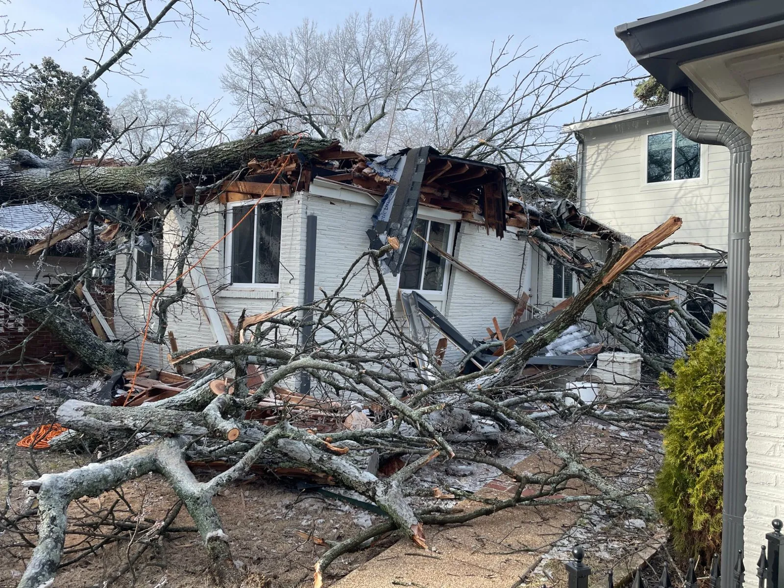 Ice storm damage — a fallen tree collapsed the roof of a Memphis home onto the structure below